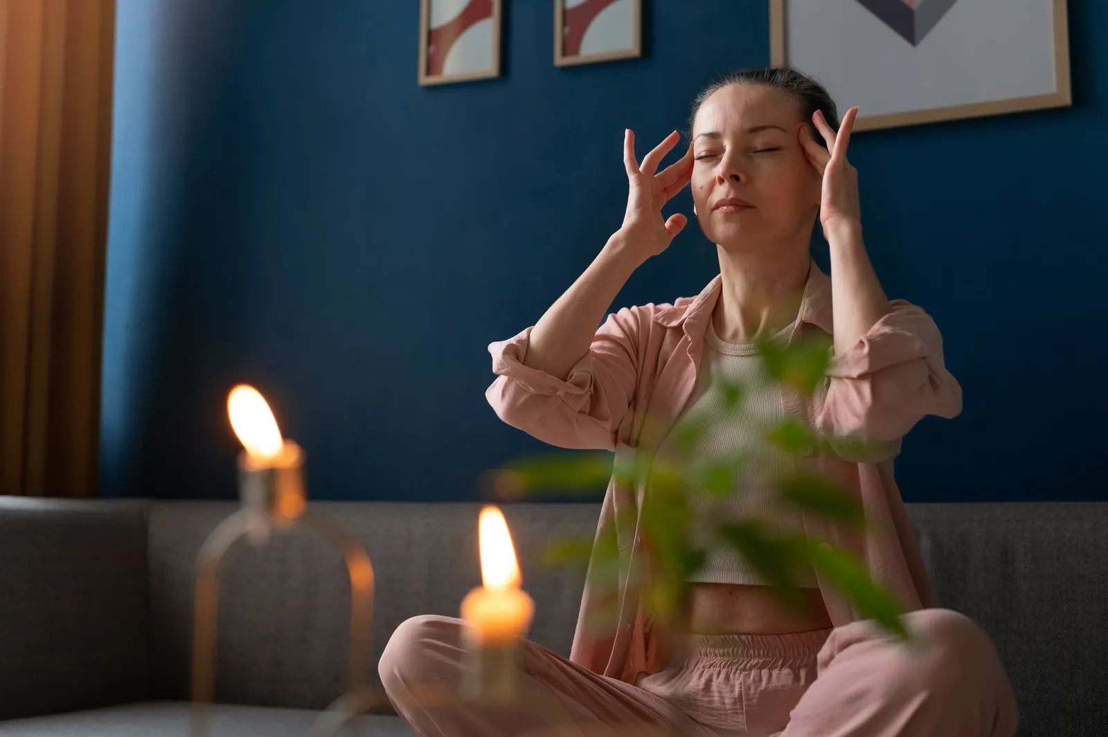 A woman sitting quietly with her eyes closed, taking a deliberate pause in a calm room